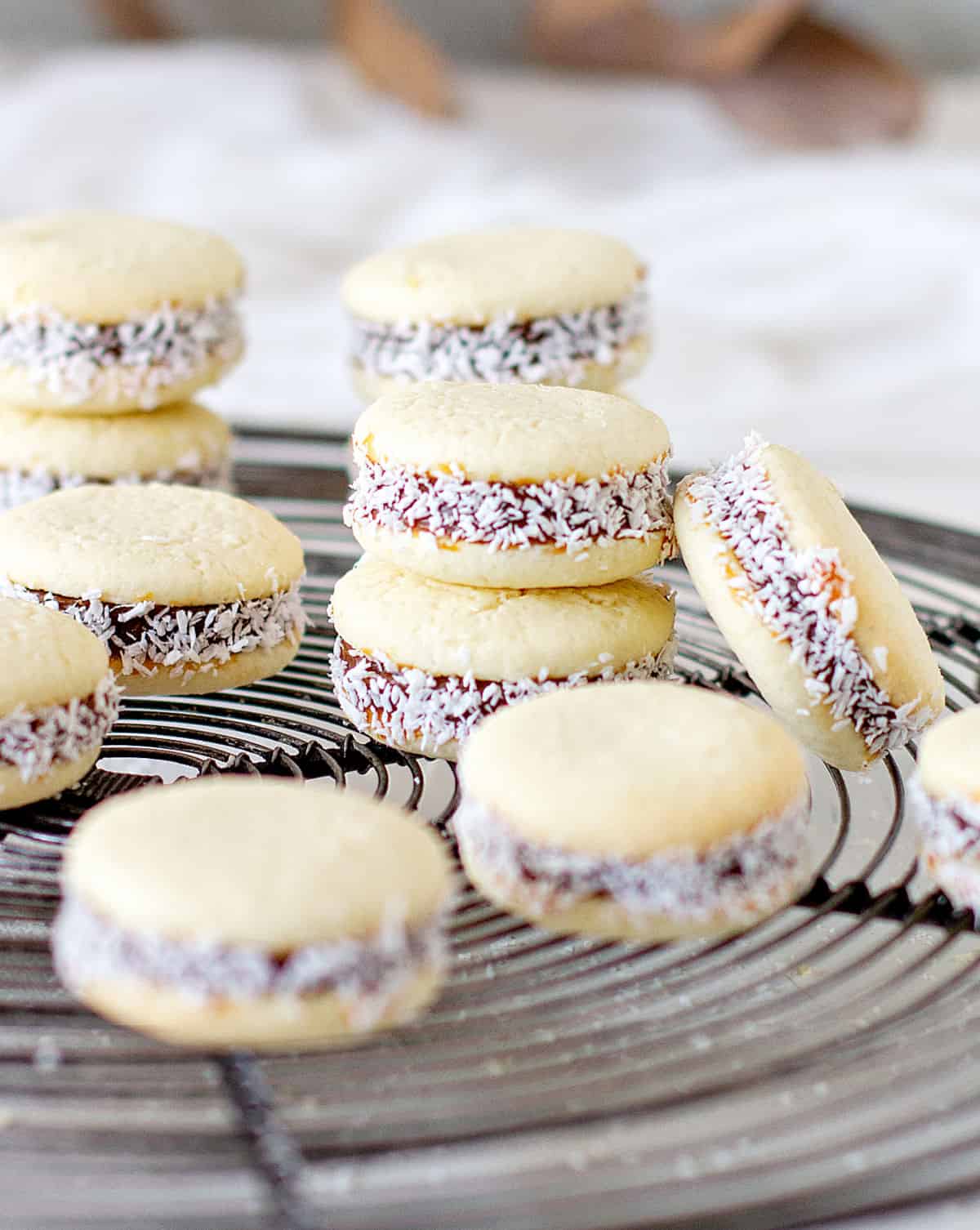 Stacks of Argentine alfajores on a wire rack. White background. 