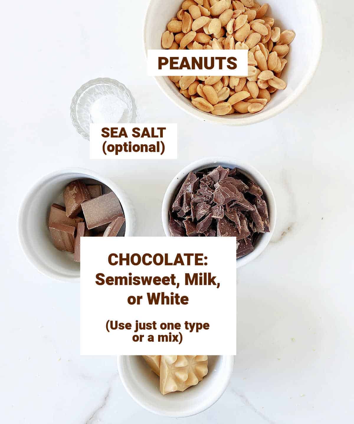 White marble surface with bowls containing different chocolates, peanuts and salt.