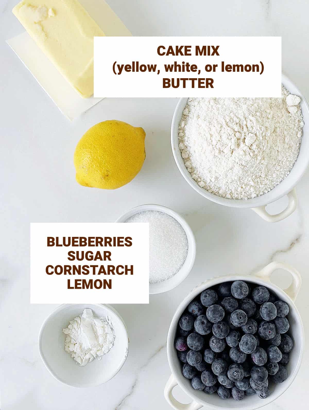 Bowls with ingredients for blueberry dessert including cake mix, lemon, sugar, butter. White surface; text overlay.