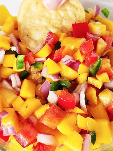 Close up mango peach salsa with corn chip.
