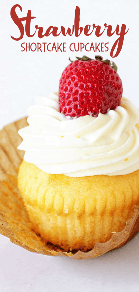 Red text overlay on cream-topped vanilla strawberry cupcake. Beige paper liner. White background.