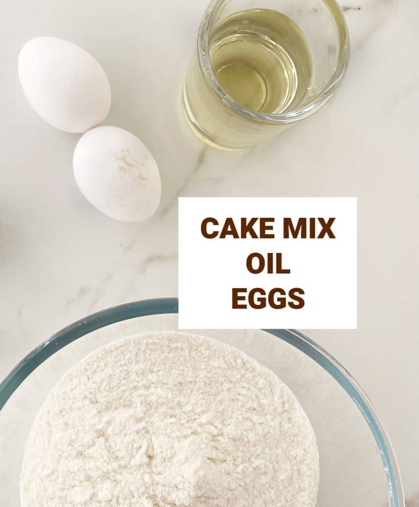 Ingredients for cake mix cookies including eggs and oil. White marble surface. 