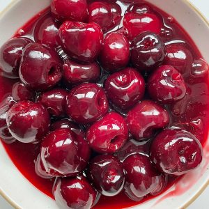 Bowl with cherry topping with syrup. Close up image.