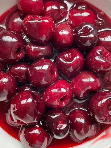 Bowl with cherry topping with syrup. Close up image.
