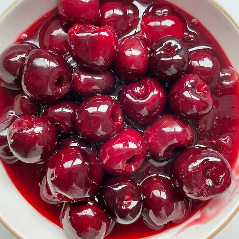 Bowl with cherry topping with syrup. Close up image.