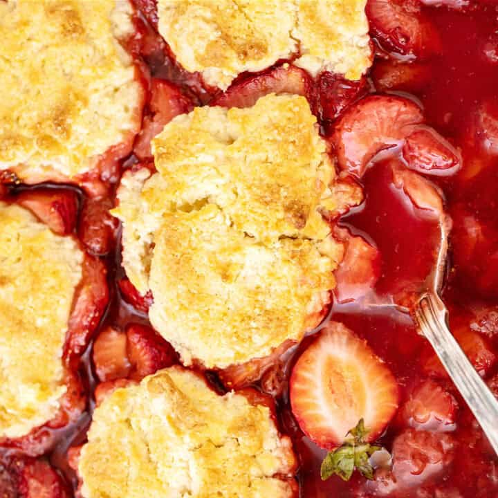 Baked strawberry cobbler close up. Silver spoon.