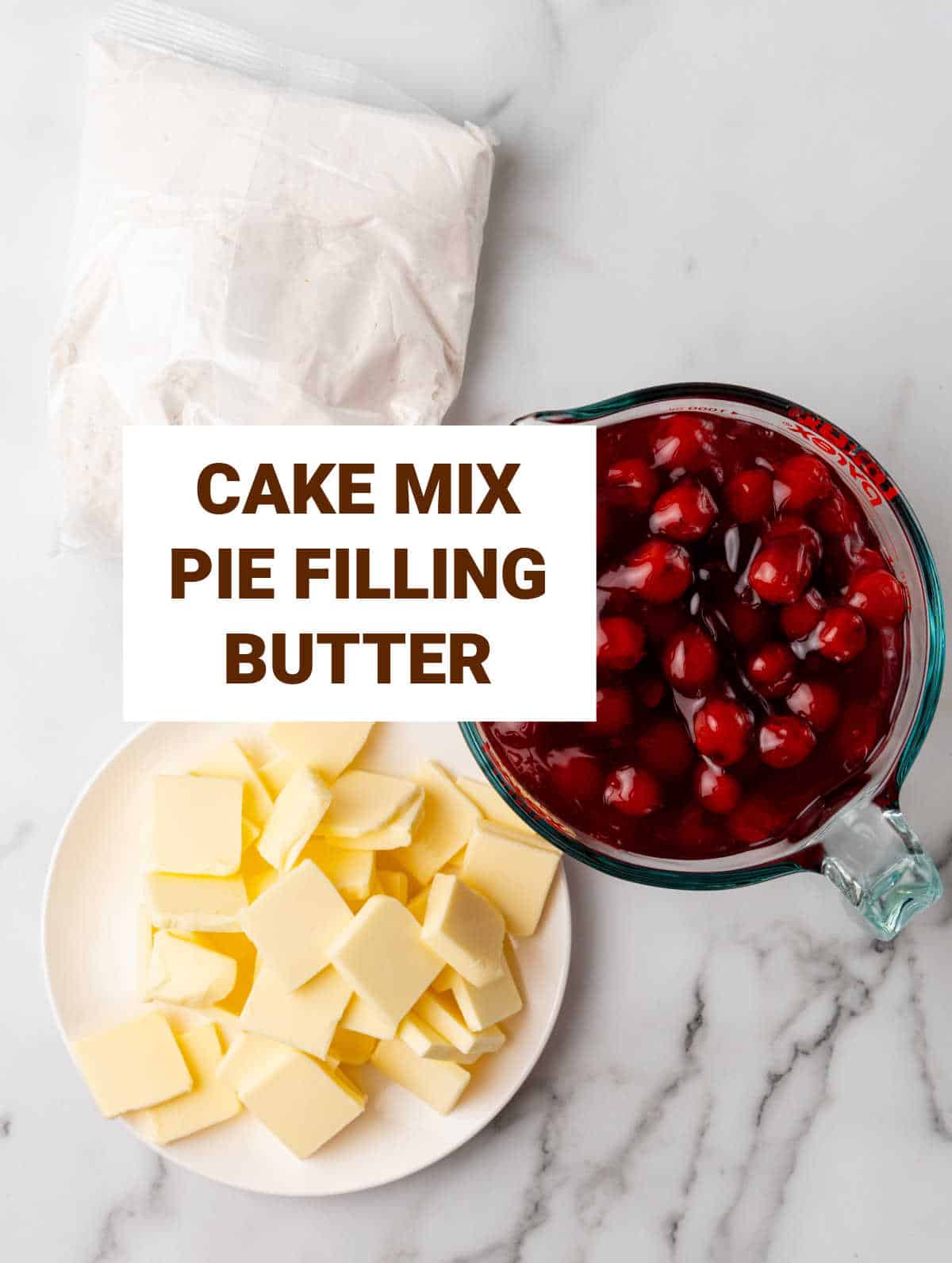 White marble with ingredients for cherry dump cake including butter, cake mix, and pie filling.