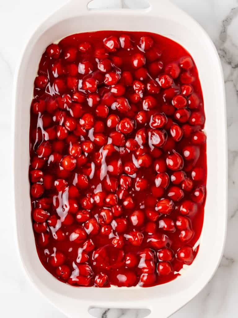 Cherry pie filling in a white rectangular dish.