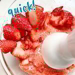 Red and blue text overlay on strawberries and sugar being blended.