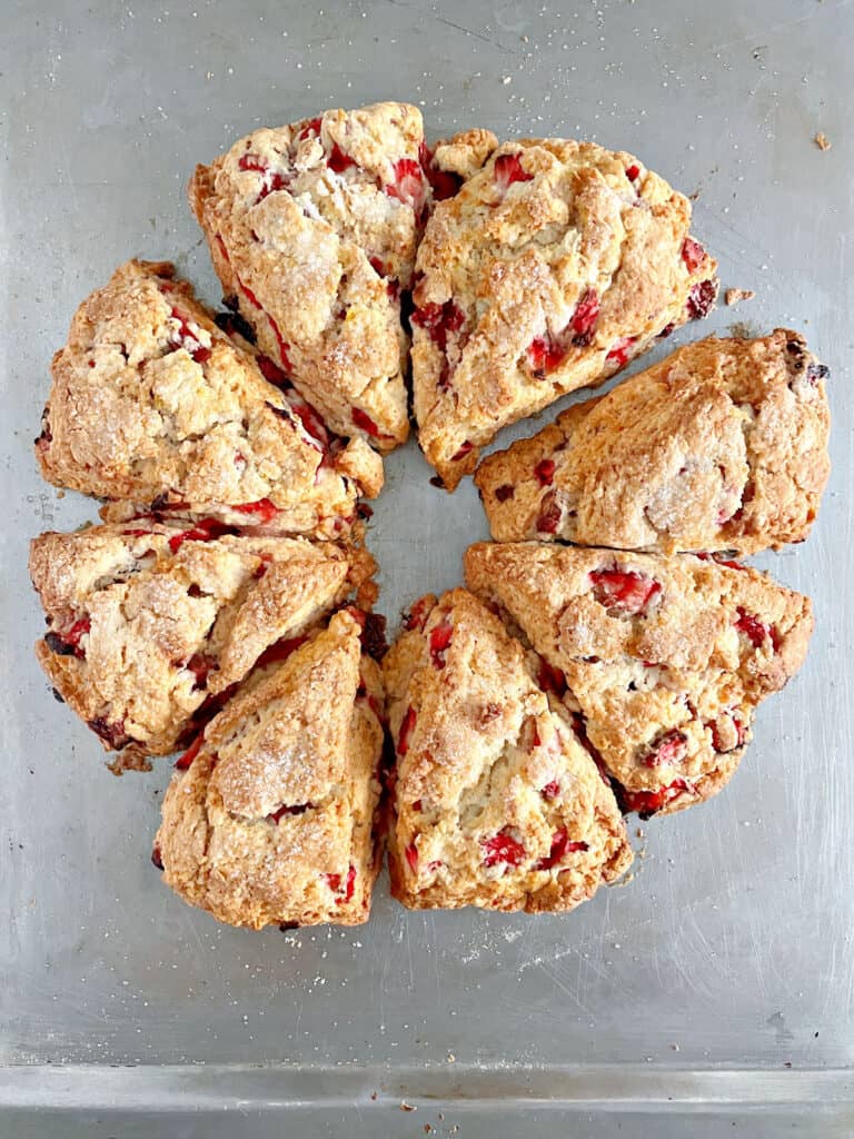 Baked strawberry scone triangles on a metal sheet. Top view.