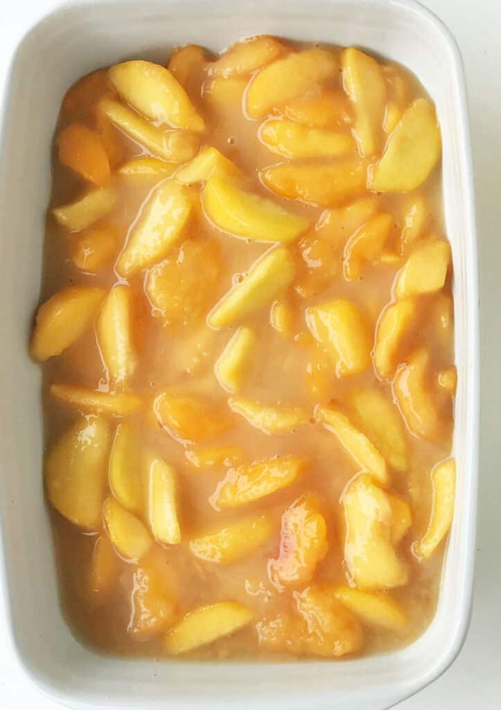 Peach pie filling in a gray rectangular baking dish.