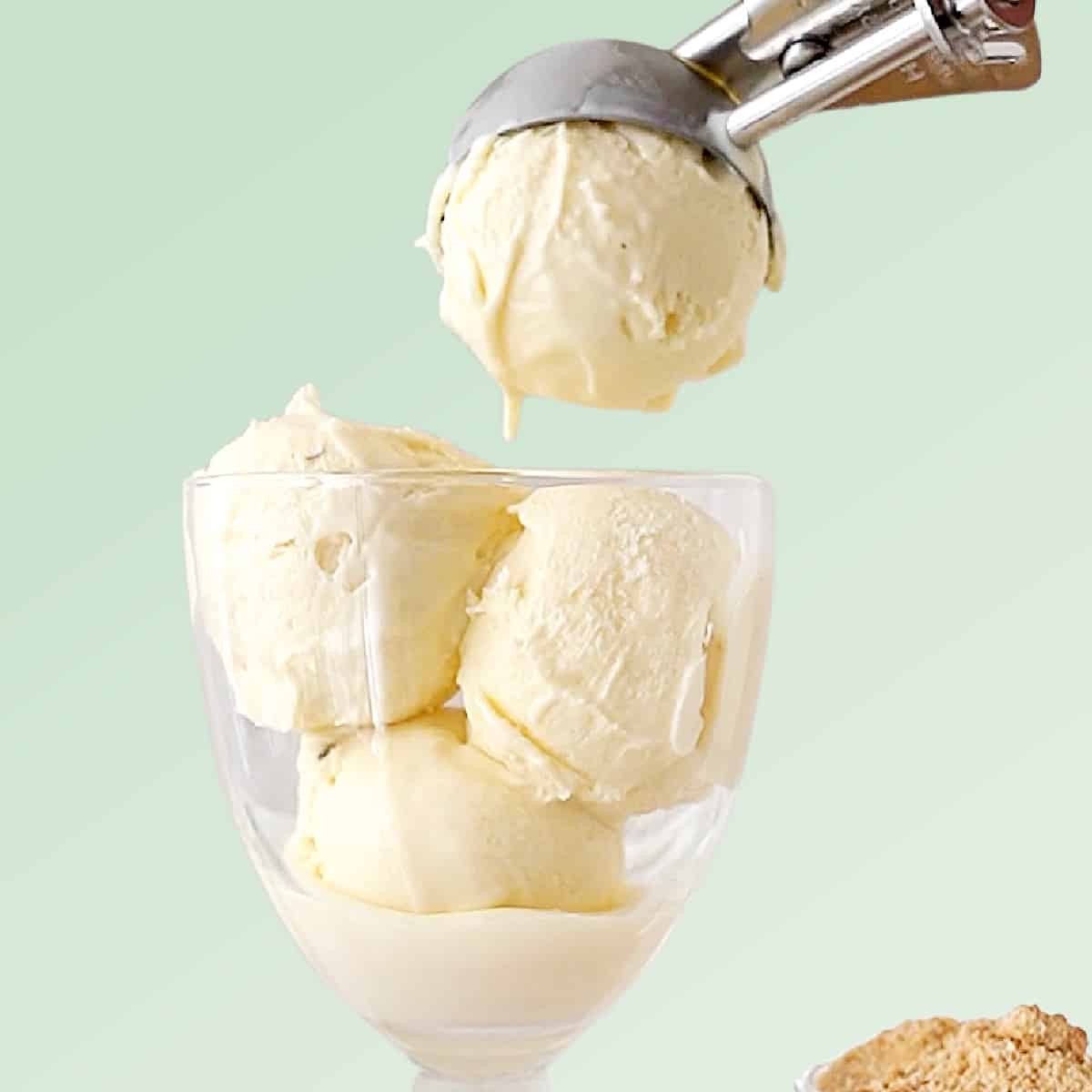 Green background with vanilla ice cream being scooped into a glass. 