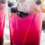 Black and white text overlay on glass of blueberry lemonade.