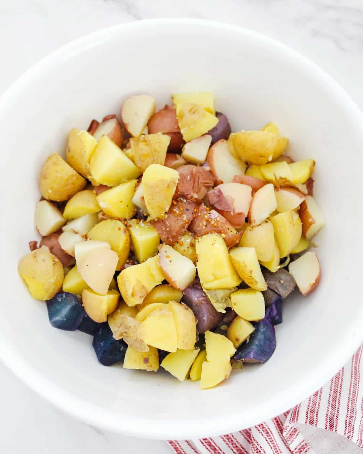 Baked colored potato chunks in a white bowl.