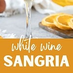 Orange and white text overlay on glass and pitcher with white sangria.