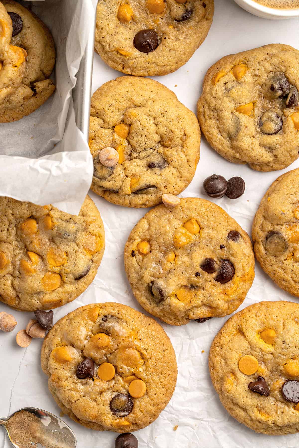Flay lay of butterscotch chocolate chip cookies on white paper. 