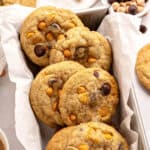 Close up butterscotch chocolate chip cookies on a white parchment lined loaf pan.