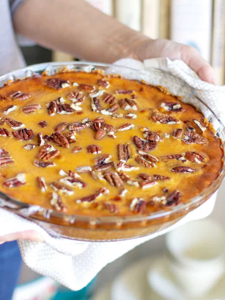 Round glass dish with sweet potato pie with pecans.