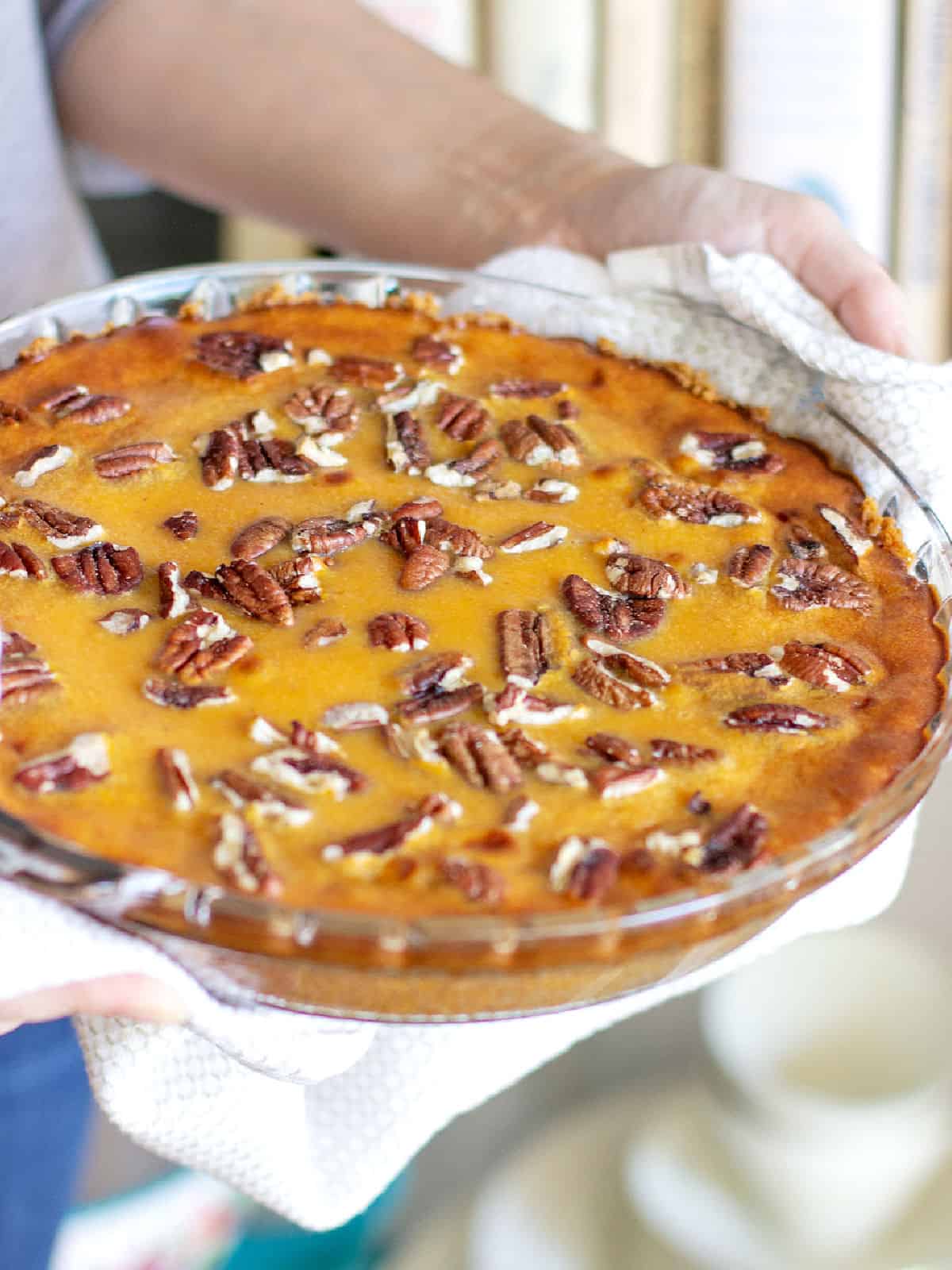 Round glass dish with sweet potato pie with pecans.