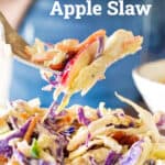 Red and white text overlay on apple slaw in a fork and stack of plates. Blue background.