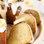 Orange and white text overlay on glazed banana bundt cake slices.