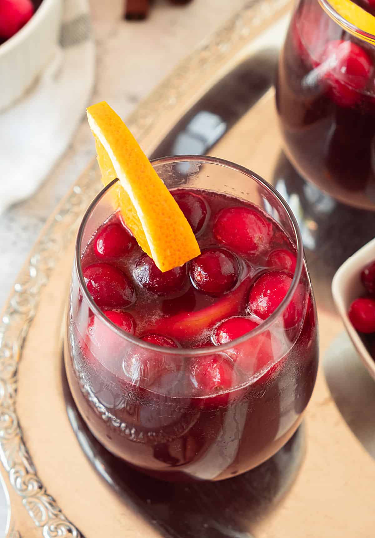 Cranberry sangria with orange slices in glasses on a metal tray. Top view. 