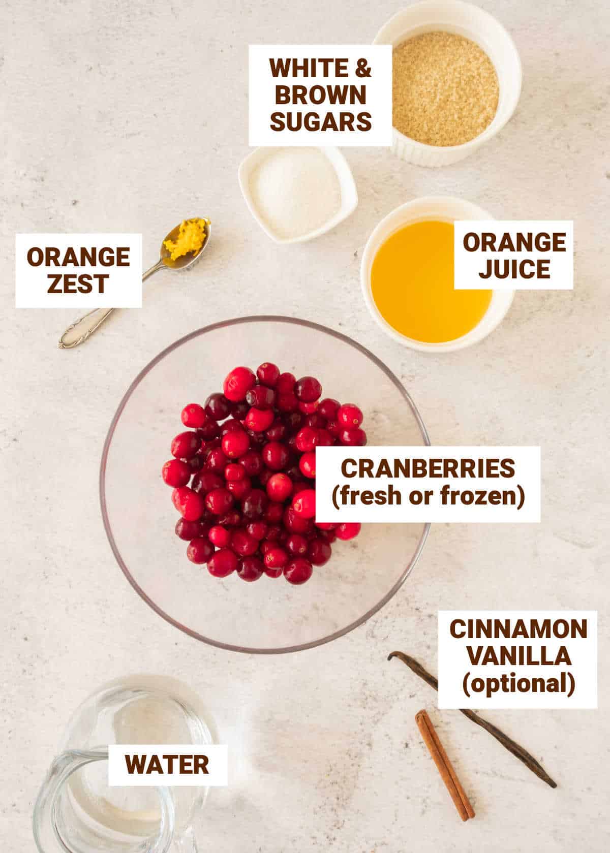 Beige surface with bowls containing ingredients for orange cranberry sauce including sugars, water, cinnamon, vanilla.