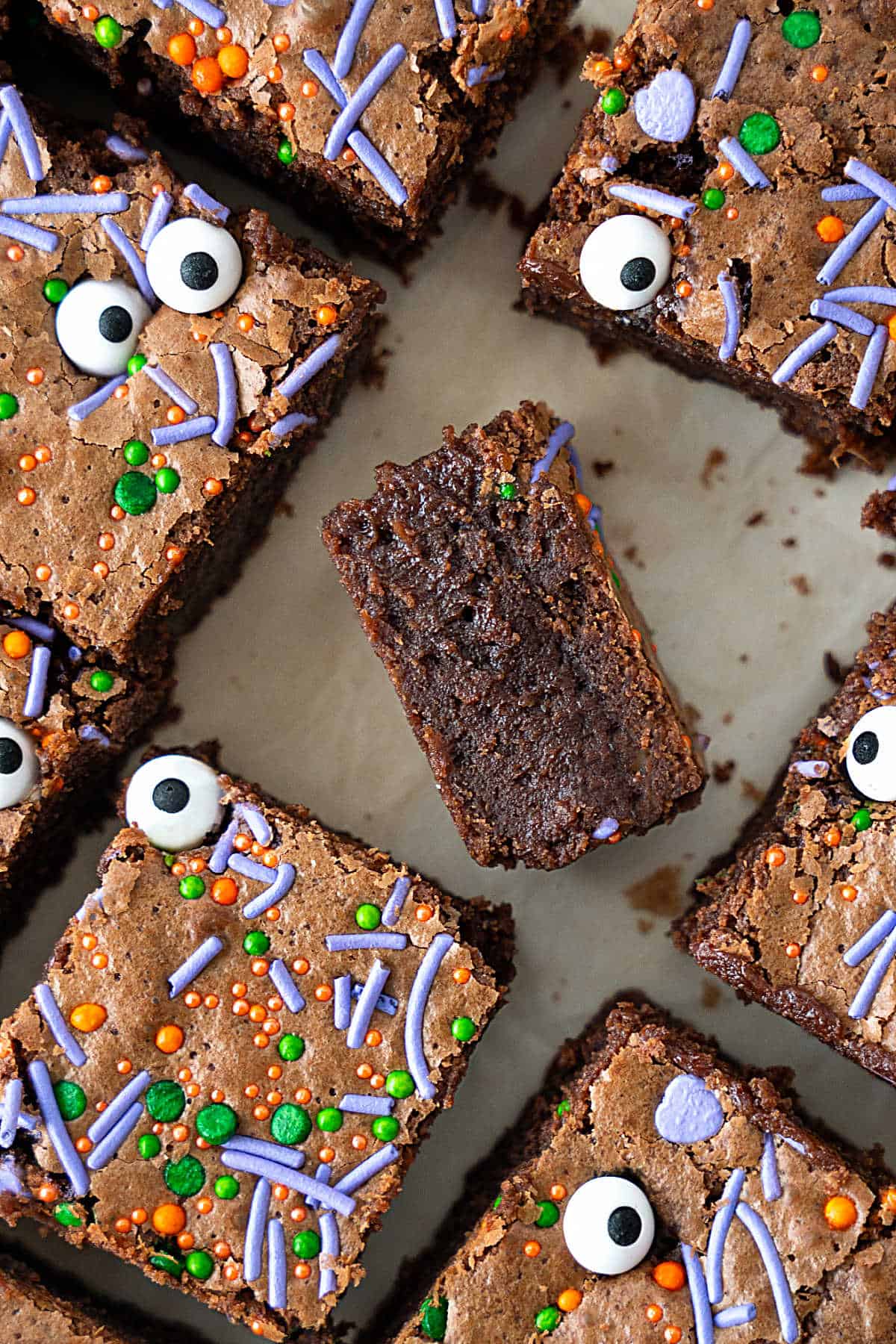 Several halloween brownies in rows with center one tipped to show inside. 