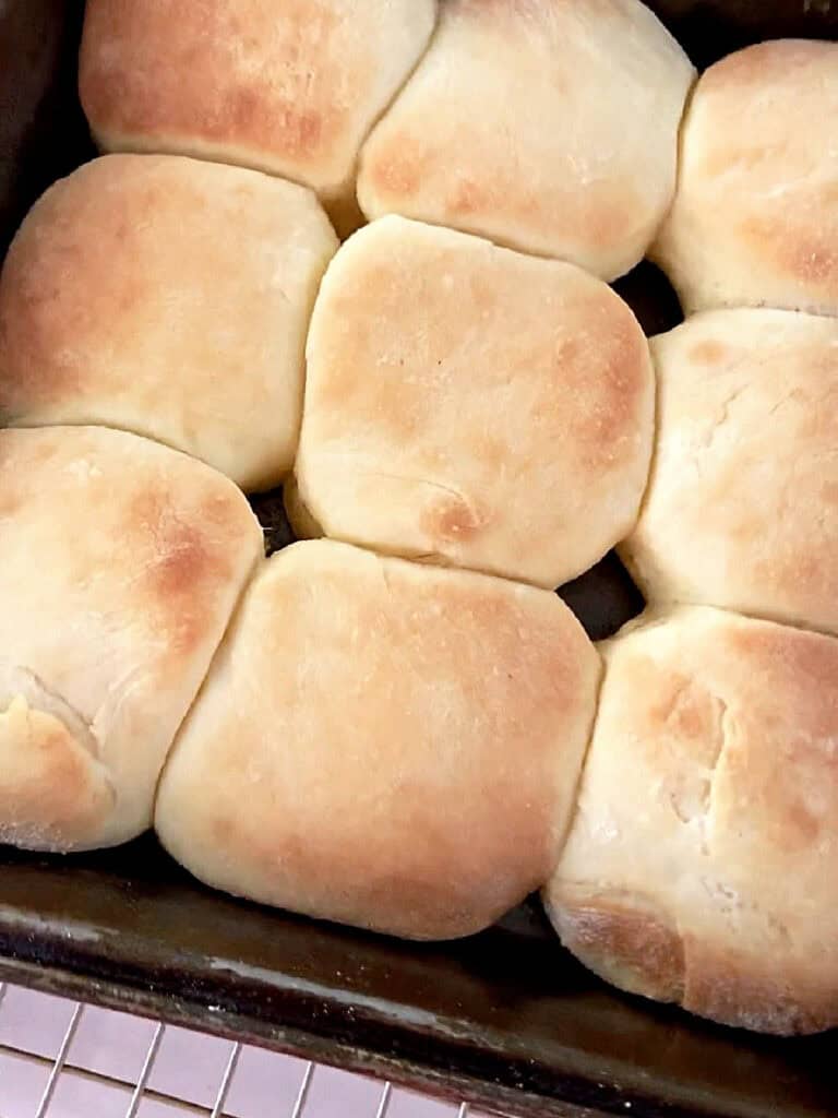 Baked sandwich buns in a metal pan.