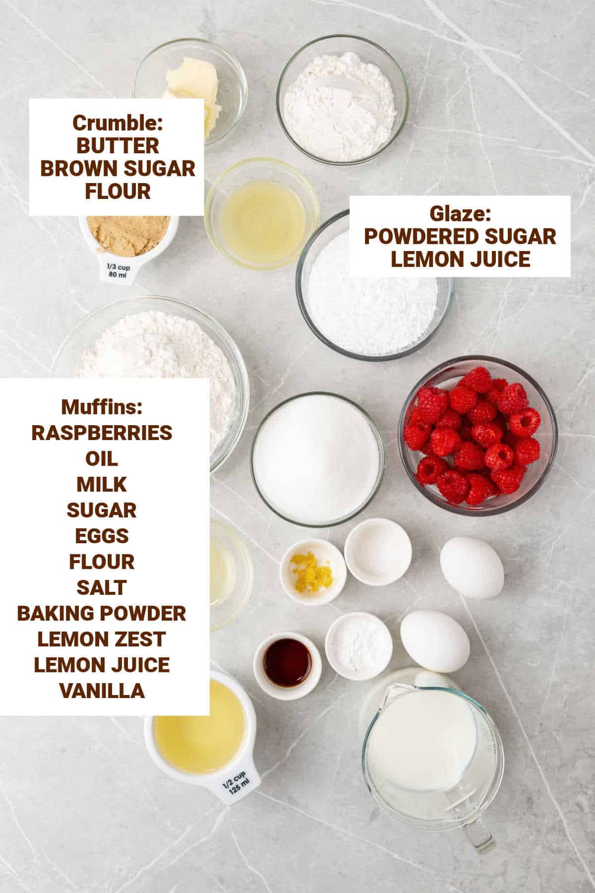 Ingredients for lemon raspberry muffins in bowls on a grey surface including oil, sugars, butter, flour mixture, lemon zest and juice, vanilla.