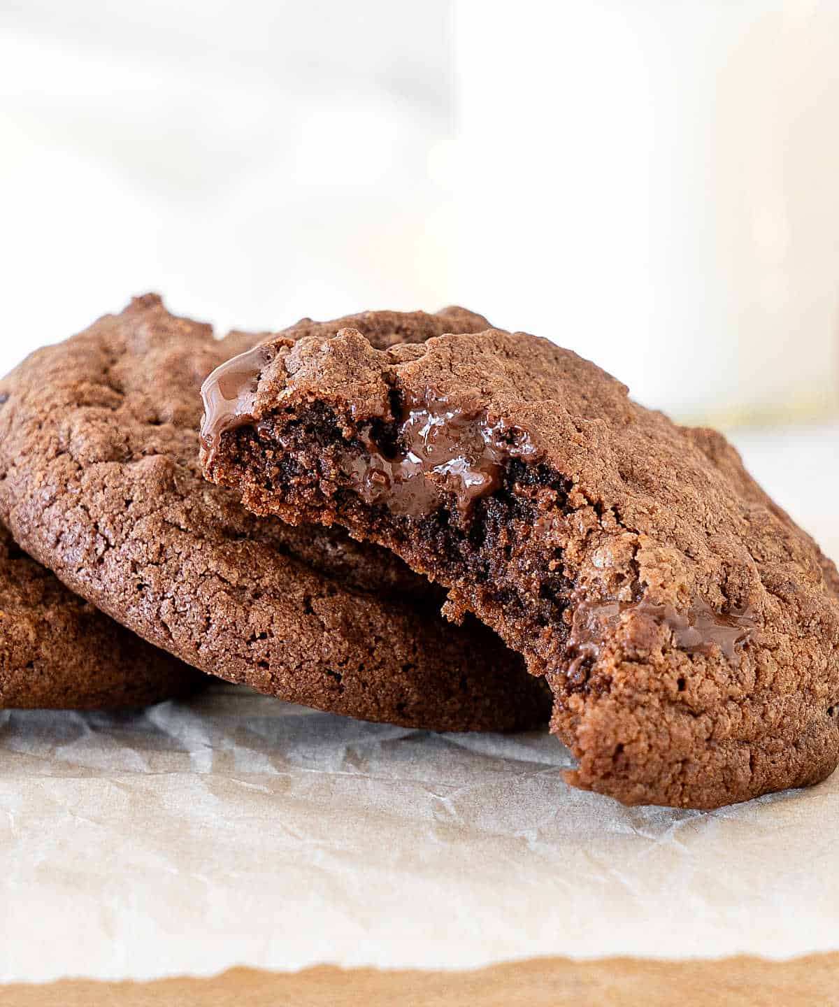 Leaning bitten chocolate cookies on a white background.