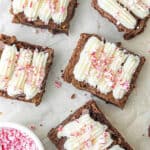 Close up brownies with cream cheese peppermint topping on white marble.