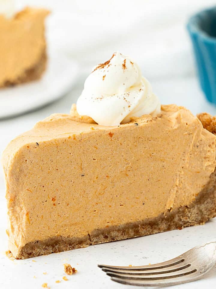 Single slice of pumpkin mousse pie with graham cracker crust. White background.