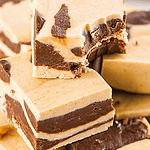 Brown and white text overlay on pile of whole and bitten marbled fudge squares.