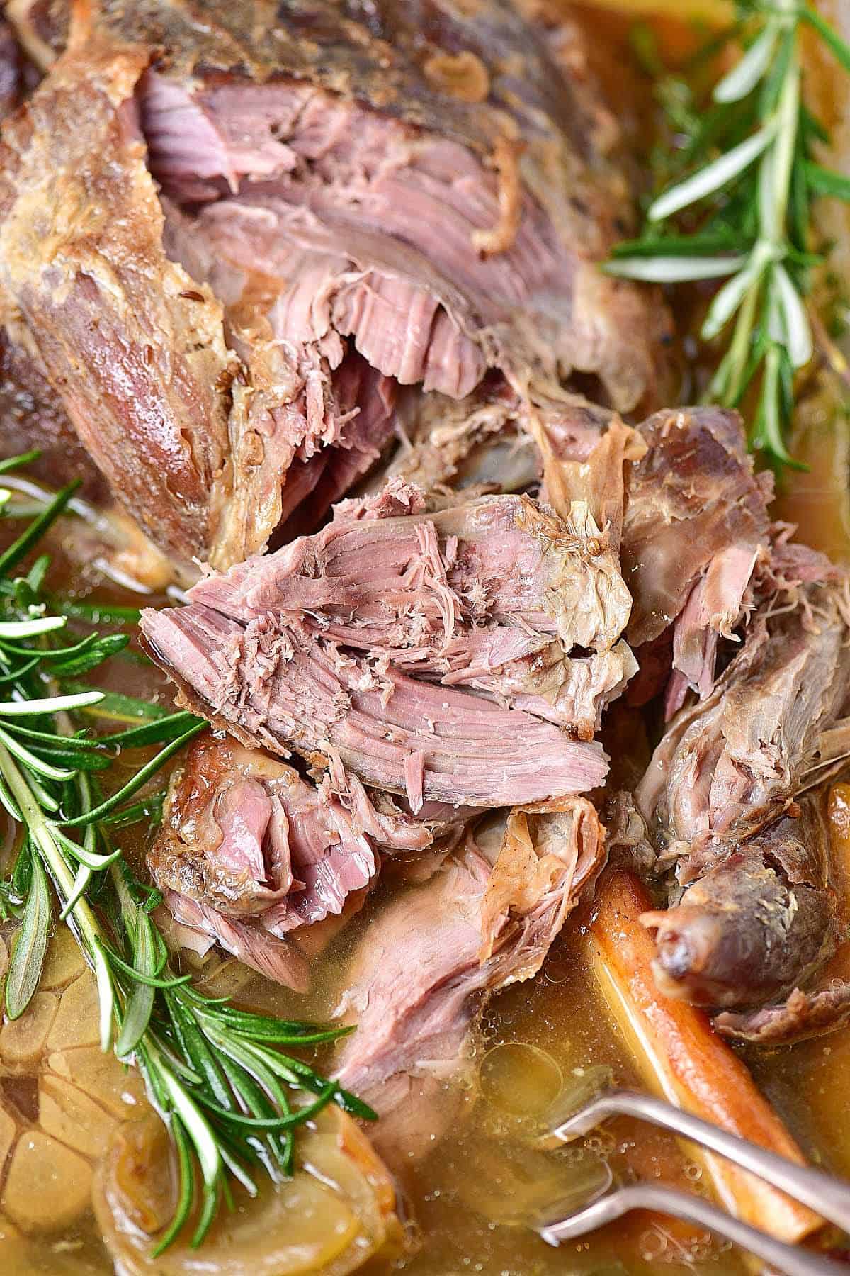 Pulled apart lamb meat with fresh rosemary. Close up image.