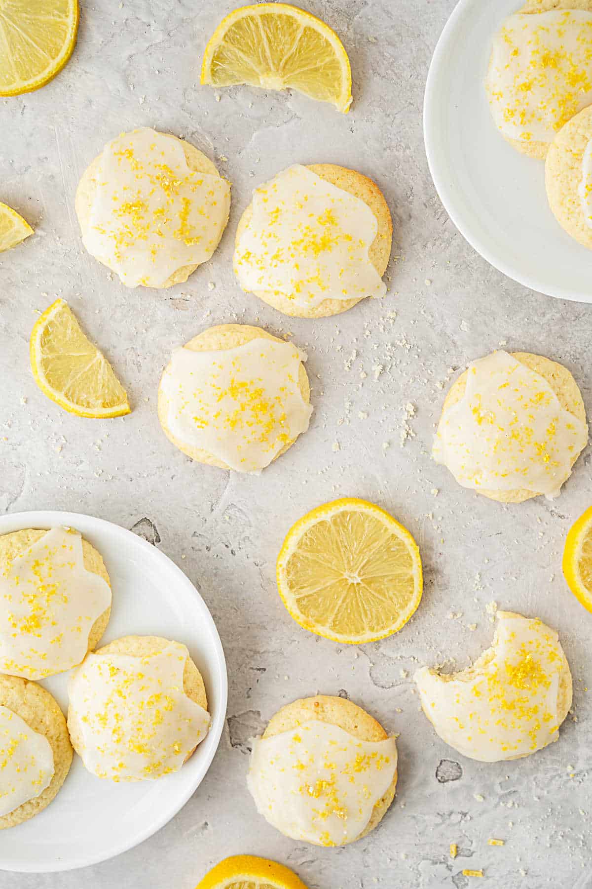 Lemon slices and glazed lemon cookies on a gray surface. Top view. 