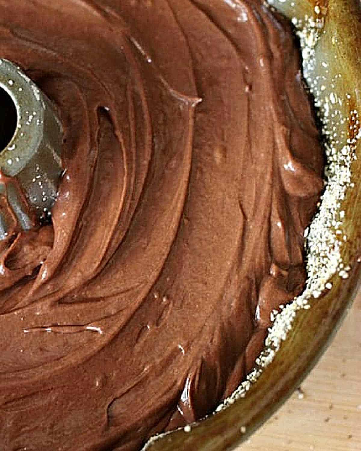 Metal bundt pan with chocolate cake batter. Close up.