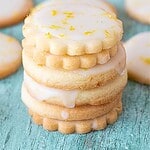 Blue and brown text overlay on stack of glazed lemon shortbread cookies. Green blue surface.
