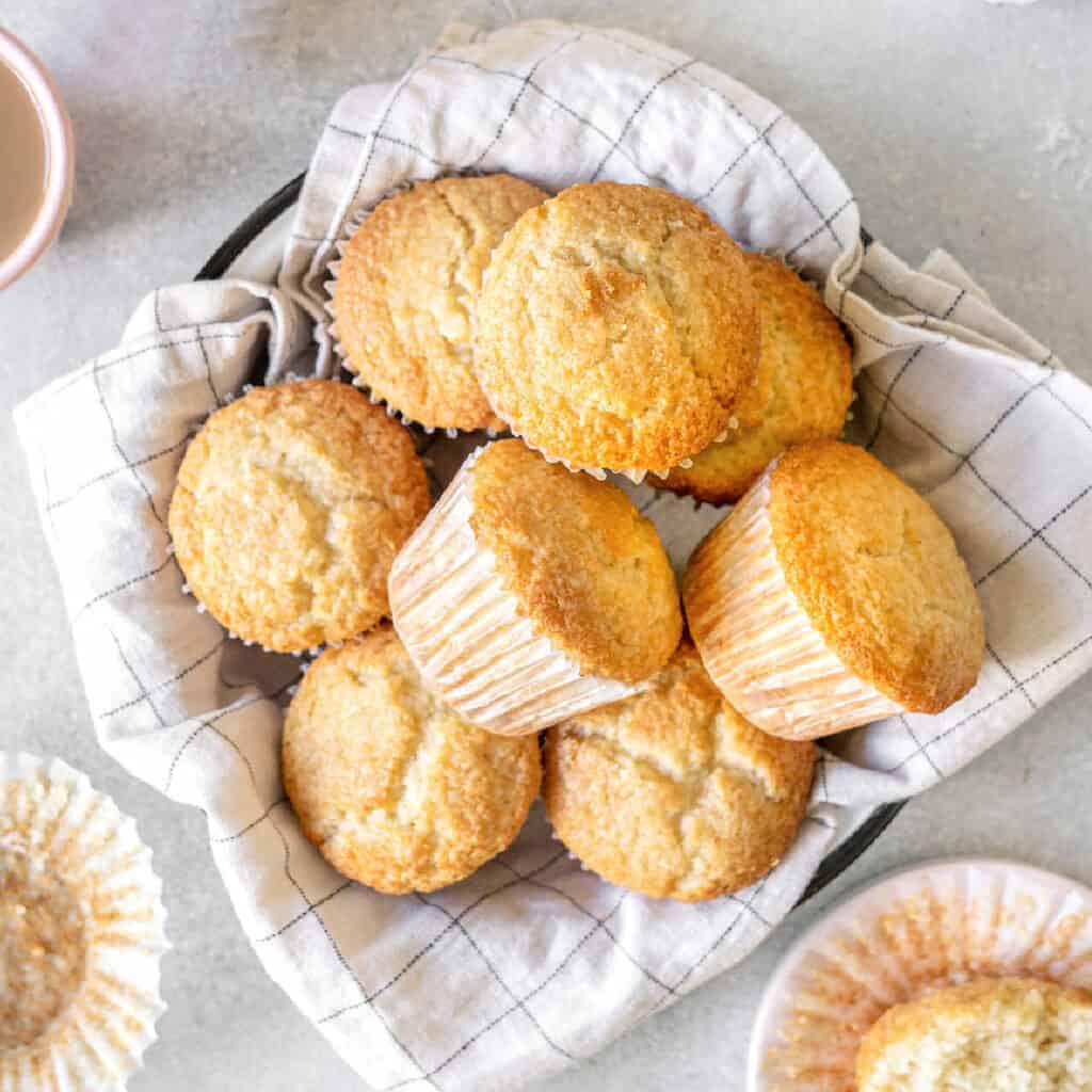 Close up top view of coconut muffins on a white checkered cloth. Light gray surface.