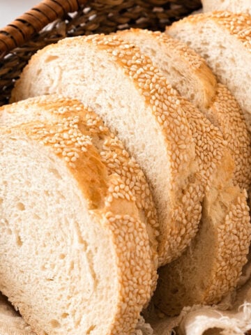 Close up slices of sesame semolina bread in a basket.