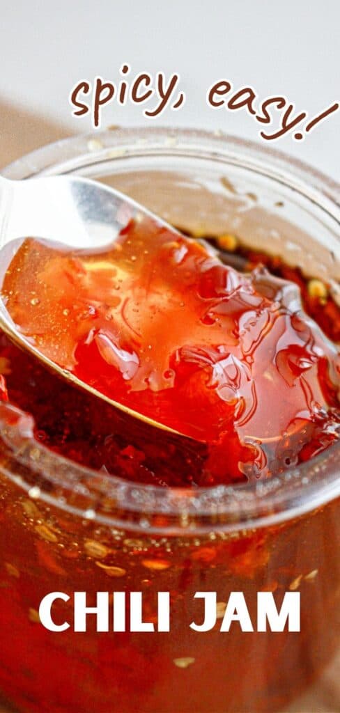 White and brown text overlay on jar and spoon of red chili jam.