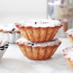 Stacked mini cakes on a white marbled surface with metal props around.
