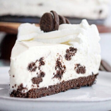 Close up of Oreo no bake cheesecake slice on a gray plate.