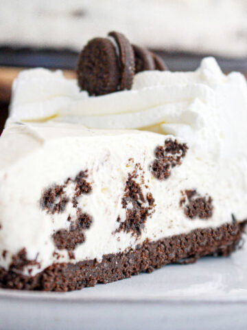 Close up of Oreo no bake cheesecake slice on a gray plate.