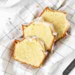 Close up of three glazed vanilla pound cake slices on checkered white blue cloth. Top view.