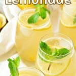 Yellow and white text overlay on glasses with ginger lemonade and mint sprigs.