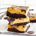 Close-up stack of pumpkin cream cheese brownies. White surface and background.