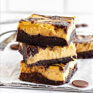 Close-up stack of pumpkin cream cheese brownies. White surface and background.