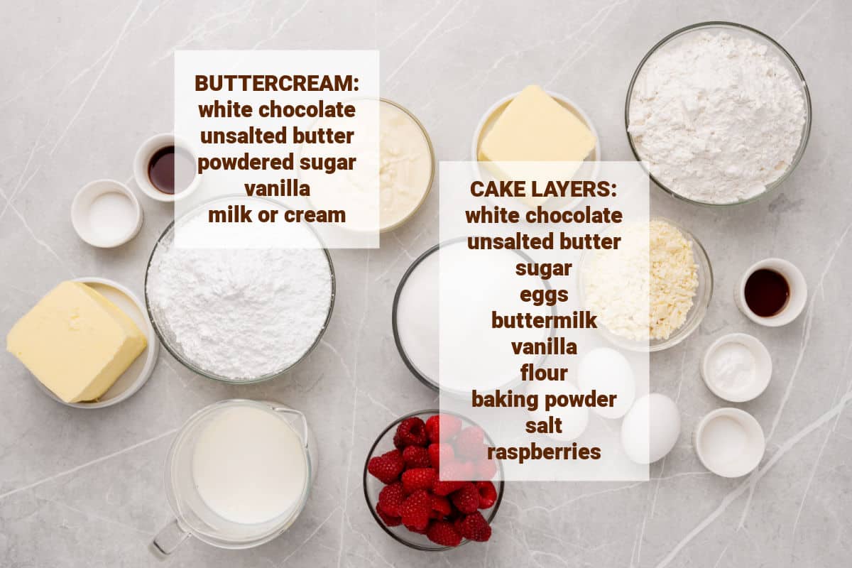 Ingredients for white chocolate raspberry cake in bowls on a gray surface.