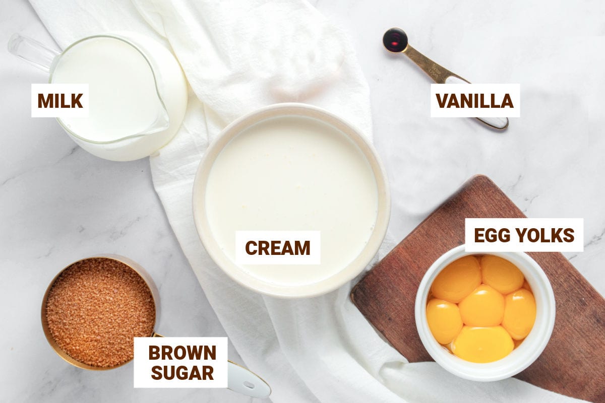 White bowls with ingredients for brown sugar ice cream including yolks and cream.